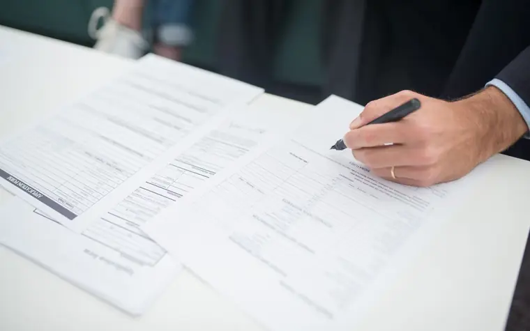 Schadenabwicklung: Versicherungsunterlagen werden unterschrieben